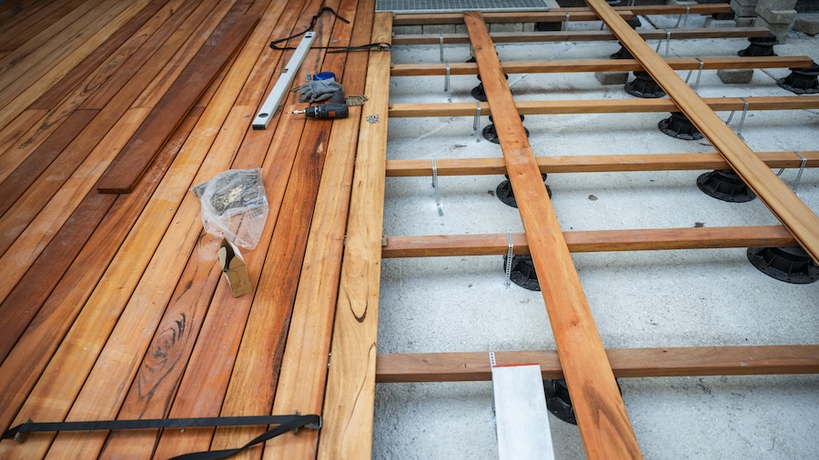 A partially built wooden floor with tools and materials scattered around.