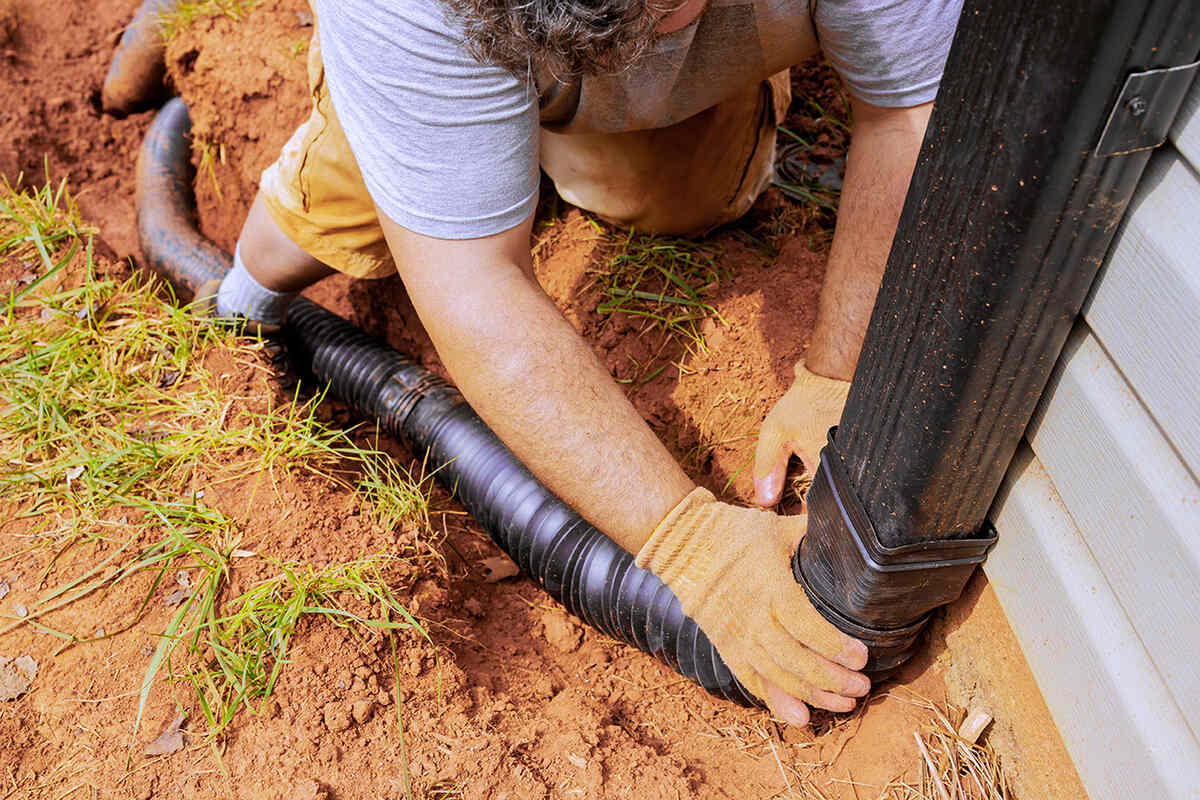 photo of a man installing a downspout extension