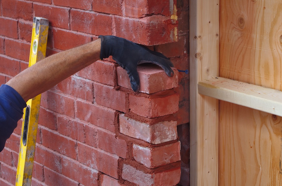 mason builder hand working brick wall construction