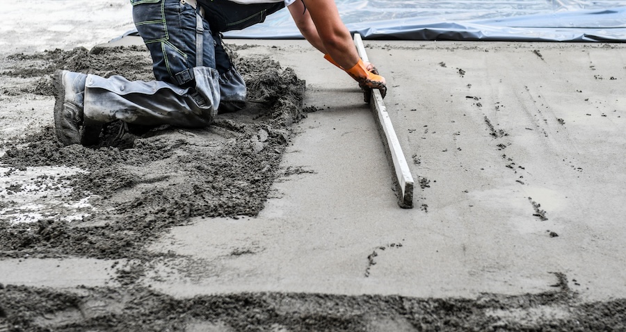 a person kneeling and laying concrete