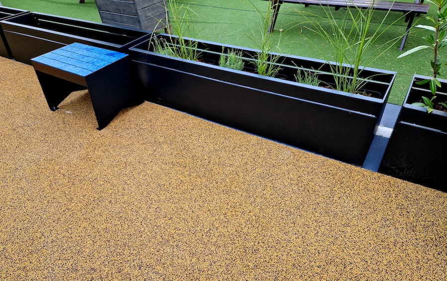 Yellow rubber concrete with plants ad a stool