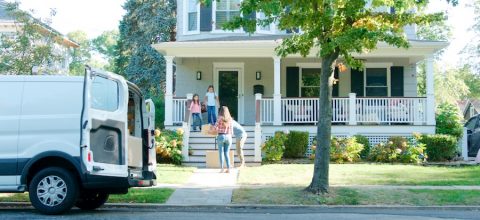 Children Helping Parents Unload Boxes From Van On Family Moving In Day